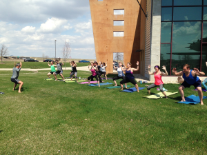 Johnson Fitness employees participate in yoga on the front lawn.